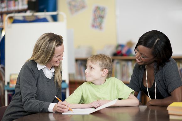 Two teachers and student reading